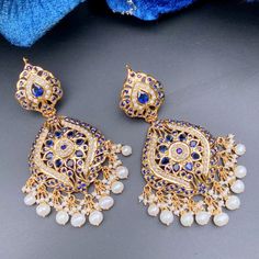 Featuring a pair of gold plated silver earrings. It has been embellished with precious freshwater pearls and sapphire look alike stones. The earrings have a bombay screw. ﻿All of Rudradhan's Gold Plated Jewellery is made using 925 Silver, real freshwater pearls and high quality ruby, emerald and sapphire beads. The default choice for studded stones used is synthetic that closely resemble original gemstones. Elegant Pearl Meenakari Earrings For Diwali, Festive Formal Pearl Drop Earrings, Formal Temple Jewelry Pearl Drop Earrings, Fusion Pearl Earrings With Meenakari For Celebrations, Fusion Style Pearl Earrings With Meenakari For Celebration, Fusion Style Meenakari Pearl Earrings For Celebrations, Formal Pearl Drop Earrings For Diwali, Elegant Gold-plated Meenakari Pearl Earrings, Elegant Meenakari Gold-plated Pearl Earrings