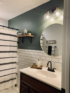 a bathroom with a sink, mirror and shower curtain