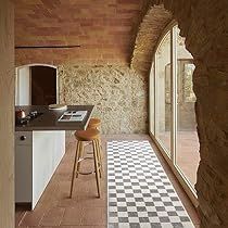 a kitchen with a checkered floor and stone walls