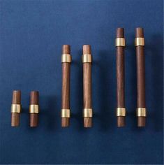 five wooden pegs lined up on a blue surface with gold trimming around them