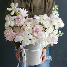 a person holding a bucket with flowers in it