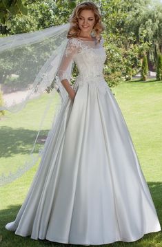 a woman in a wedding dress standing under a tree