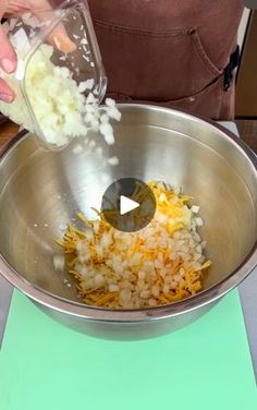 someone is adding cheese and onions to a bowl