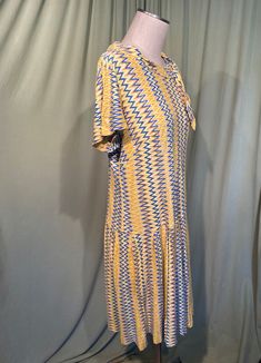 "This is a cute vintage dress from the 60s. No labels or tags, it is home sewn. No size tag. The bust measures 38\", waist 38\", see measurements below. Made of a yellow, gold, white & blue nylon in a flame style pattern. The dress is not lined. It is short sleeve with a portrait collar with small tails. The skirt has inverted pleats all around. Zips in the back with a metal zipper. The dress is in good condition, but is not perfect. There are a few pin holes, as shown in the photos. One pin Retro Daywear Dresses With Retro Print, Retro Print Dresses For Daywear, Retro Knee-length Midi Dress For Daywear, Retro Short Sleeve Midi Dress For Daywear, Blue Retro Midi Length Vintage Dress, Blue Retro Midi Vintage Dress, Retro Blue Midi Vintage Dress, Blue Vintage A-line Midi Dress, Vintage Blue A-line Midi Dress