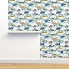 the wall paper is designed with airplanes and clouds in blue, green, yellow and white