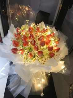 a vase filled with lots of flowers on top of a glass table next to a window