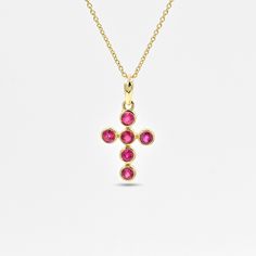 This gorgeous pendant is studded with rubies (glass filled) surrounded by 14k solid yellow gold. Ruby is said to be a powerful talisman for attracting good luck. It is thought to increase wealth, protect you from bad luck, and bring success in all your endeavours. Ruby is a July birthstone. It is a minimal yet classy holy cross pendant, making it a perfect gift for your loved ones! Product Details Material : 14K Solid Yellow Gold Gemstone : Ruby (glass filled) Gemstone size : 3 mm Pendant Width : 10 mm Pendant Height : 21 mm Item weight : 1 gram Please select the chain if required from the available options. Chains are available in many different sizes. Please contact us for customisation. Chain details Material: 14k solid yellow gold  Chain thickness: 0.5 mm Ruby Necklace In Yellow Gold As A Gift, Yellow Gold Ruby Necklace As Gift, Yellow Gold Ruby Necklace For Gift, Yellow Gold Ruby Necklace Gift, Celebration Yellow Gold Ruby Necklace, Gold Ruby Necklaces With Bezel Setting, Spiritual Ruby Jewelry In Yellow Gold, Spiritual Yellow Gold Ruby Jewelry, Gold Ruby Pendant Birthstone Necklace