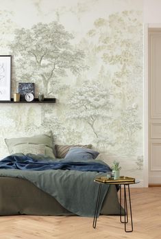 a bed sitting under a tree wallpaper next to a table with a plant on it