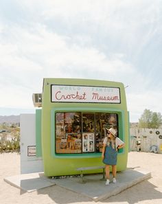 a woman standing in front of a green booth