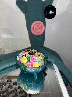 a stuffed animal is sitting on top of a glass bowl