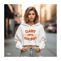 "Classy Until Kickoff Crop Hoodie, SBLVIII Sweatshirt, Cute Football Sweatshirt for big game, Swiftie Fan Football Hoodie, Kelce Bowl Game 💖 WELCOME TO MY STORE, I'M SO HAPPY YOU STOPPED BY💖 My main aim is to ensure your happiness and satisfaction. I truly value your patronage. If you have any questions or would like a custom-made design, please don't hesitate to reach out. Even if you love the design but aren't fond of the available sweatshirt colors, feel free to contact me. I'll go above and beyond to ensure your satisfaction.  To communicate with me regarding any inquiries, concerns, or customization requests, please use the \"Add message to seller\" link on the checkout page. Shirt Details: Lane Seven Cropped Hoodie *85% combed ringspun cotton, 15% polyester *Medium fabric  *Relaxed Classy Until Kickoff, Sweatshirt Colors, Bowl Game, Football Sweatshirt, Sweatshirt Cute, Crop Hoodie, Big Game, Cropped Hoodie, So Happy