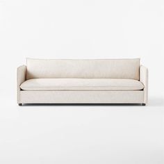 a white couch sitting on top of a white floor