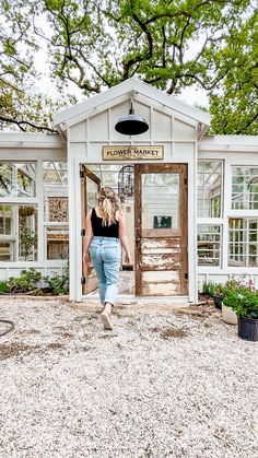 a woman walking into a small white building