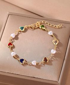 This multicoloured beaded bracelet, is the perfect dainty pearl bracelet gift for lovers of colourful freshwater pearl jewelry and heart charm bracelets. This beautiful charity bracelet combines multicolour pearls a dainty silver heart chart to create an elegant and dainty everyday piece of jewellery. Small freshwater pearls sit alongside silver plated spacer beads and a rose gold plated heart bead, finished with a silver toggle clasp for easy wear. Elegant Heart-shaped Jewelry With Colorful Beads, Elegant Heart-shaped Colorful Beads Jewelry, Elegant Heart-shaped Colorful Beaded Jewelry, Elegant Heart-shaped Bracelets With Colorful Beads, Multicolor Pearl Charm Jewelry As Gift, Multicolor Jewelry With Pearl Charm As Gift, Multicolor Jewelry With Pearl Charm For Gift, Multicolor Pearl Charm Jewelry Gift, Dainty Heart-shaped Jewelry With Colorful Beads