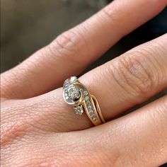 a woman's hand with a gold and diamond ring on her left hand,