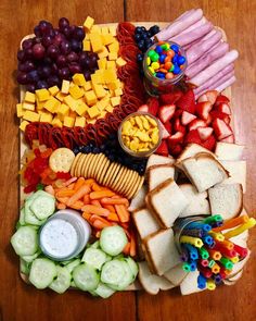 a wooden table topped with lots of different types of snacks and fruit on top of it