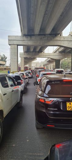 cars are lined up on the road under an overpass