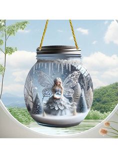 a glass jar with a fairy sitting on it's side in front of a window