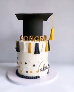 a graduation cake that is decorated with gold and black tassels