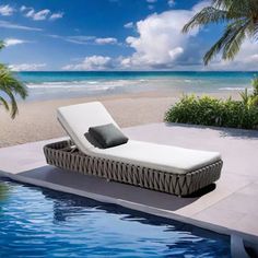 a lounge chair sitting on top of a swimming pool next to the ocean and palm trees