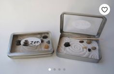 two tins with rocks in them sitting on a table