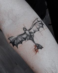 a bat tattoo on the arm of a man