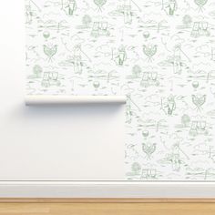 a white wall with green drawings on it and a wooden floor in front of it