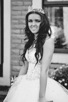 a young woman in a white dress and tiara