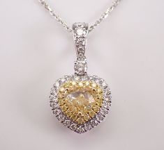 18K White Gold Canary Diamond Heart Pendant with Chain. This pendant is set with a center natural Heart shaped Brilliant Diamond, eighteen Round Brilliant side Canary Diamonds and thirty-one Round Brilliant White/Colorless Diamonds. The Yellow Canary Heart shape center Diamond is SI1 in clarity and weighs 1.00 carat.  The rest of the Fancy Yellow Diamonds are SI/I1 in clarity and amount to a total of .11 carats. The White Brilliant diamonds set in this pendant are H color, SI clarity and weigh a total of .41 carat.  The total diamond weight of this necklace is 1.52 carat. This pendant is 18KT White and Yellow Gold (the yellow diamonds are set in yellow Gold), comes with an 18" 18KT White Gold chain (that has diamond stations on the chain) and together weighs 4.5 grams. The pendant alone me Gia Certified Heart Cut Jewelry For Wedding, Gia Certified Pendant Necklaces For Anniversary, Gia Certified Pendant Necklace For Anniversary, Gia Certified White Gold Jewelry For Valentine's Day, Double Heart Diamond Jewelry With Gemstones, Yellow Diamond Necklace For Anniversary, Yellow Gold Gia Certified Necklace For Wedding, Gia Certified Yellow Gold Necklace For Wedding, White Double Heart Jewelry With Vvs Clarity