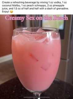 a pink drink in a glass on top of a table