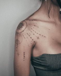 the back of a woman's shoulder with stars and planets on it