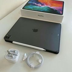 an apple ipad pro with its box and charger next to it on a table