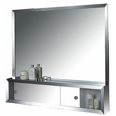 a bathroom mirror sitting on top of a shelf next to a bottle and soap dispenser