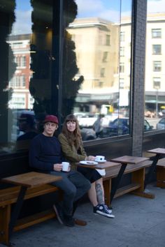 two people sitting on benches in front of a window