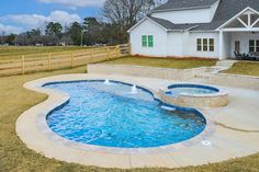 a backyard with a pool and hot tub in the middle, surrounded by grass area