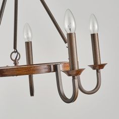 a chandelier with five lights hanging from it's arms and wood accents