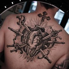 the back of a man's heart and cross tattoo