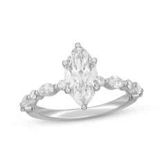 a white gold ring with an oval cut diamond and pear shaped diamonds on the band