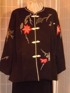 I made this black silk jacket from a Japanese kimono.  It is semi fitted, fully lined and absolutely unique with princess seams and a flattering line. The soft black silk has Japanese dyed motifs using the tie-dye technique called "shibori" with red and white flowers on a background of textured woven black silk.  Textured shibori panels on front, back and sleeves contrast subtly with solid black side front and back pieces.  The jacket has a jewel neckline and is trimmed with white piping and a black braid trim.  It closes with decorative braided "frogs". Wear it over pants, dress or skirt - dress it up or down. Great for special occasions, out to dinner, or to the office. No one will ever have a jacket like this and it will never go out of style. Made and kept in a smoke free environment. Elegant Embroidered Silk Kimono, Formal Long Sleeve Kimono For Spring, Formal Long Sleeve Spring Kimono, Elegant Long-sleeved Kimono With Floral Embroidery, Elegant Long Sleeve Kimono With Floral Embroidery, Elegant Long Sleeve Kimono For Tea Ceremony, Elegant Black Kimono With Floral Embroidery, Elegant Black Embroidered Kimono, Elegant Black Floral Embroidery Kimono