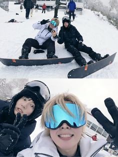 two snowboarders sitting in the snow and one is holding his hand up with both hands