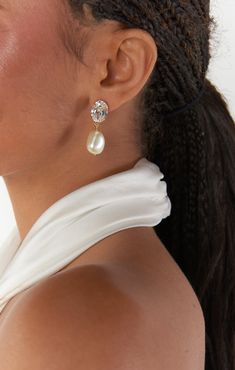 a close up of a person wearing some kind of earring with pearls on it