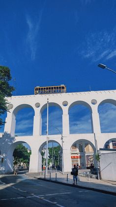 a white building with arches on the side and a person standing in front of it