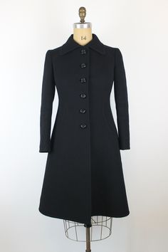 1960s Vintage EMILIO SCHUBERTH Black Wool Coat Brand: Emilio Schuberth Origin: Italy Fits like: EU M-L Measurements: Shoulder to Shoulder - 40cm/15,8" Bust - 100cm/39,4" Waist -88cm/34,6" Length - 102cm/40,2" Sleeve Length - 58,5cm/23" Displayed on the mannequin with the measurements: 99-73-101cm (39- 28,7- 39,8") Condition: Very good **Please note that Standard Shipping does not include a tracking code, if you would like a tracked shipping you can upgrade it in the basket.** Retro Fitted Outerwear With Covered Buttons, 1970s Fitted Outerwear With Button Closure, Vintage Outerwear With Button Cuffs For Office, Vintage Fitted Outerwear For Office, Fitted Vintage Outerwear For Office, 1960s Coat, Italy Fits, Retro Coat, Black Wool Coat