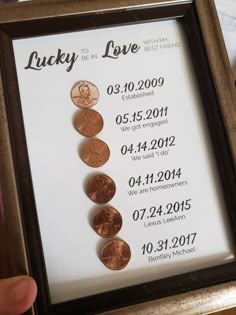 a person holding up a framed coin display