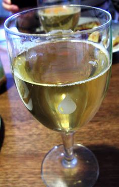 two glasses of wine sitting on top of a wooden table