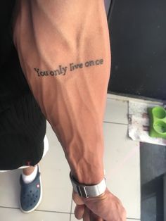 a man with a tattoo on his arm that says you only live once in black ink