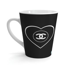 a black and white coffee cup with a heart shaped chanel logo on the side