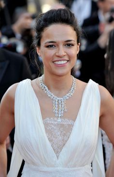 a woman in a white dress smiling at the camera