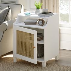 a white end table with books and a clock on it