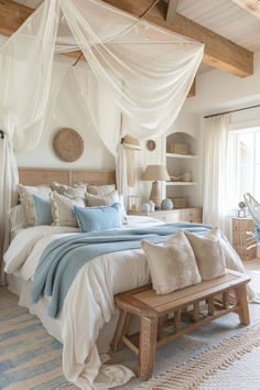 a large bed sitting under a white canopy in a bedroom next to a wooden bench